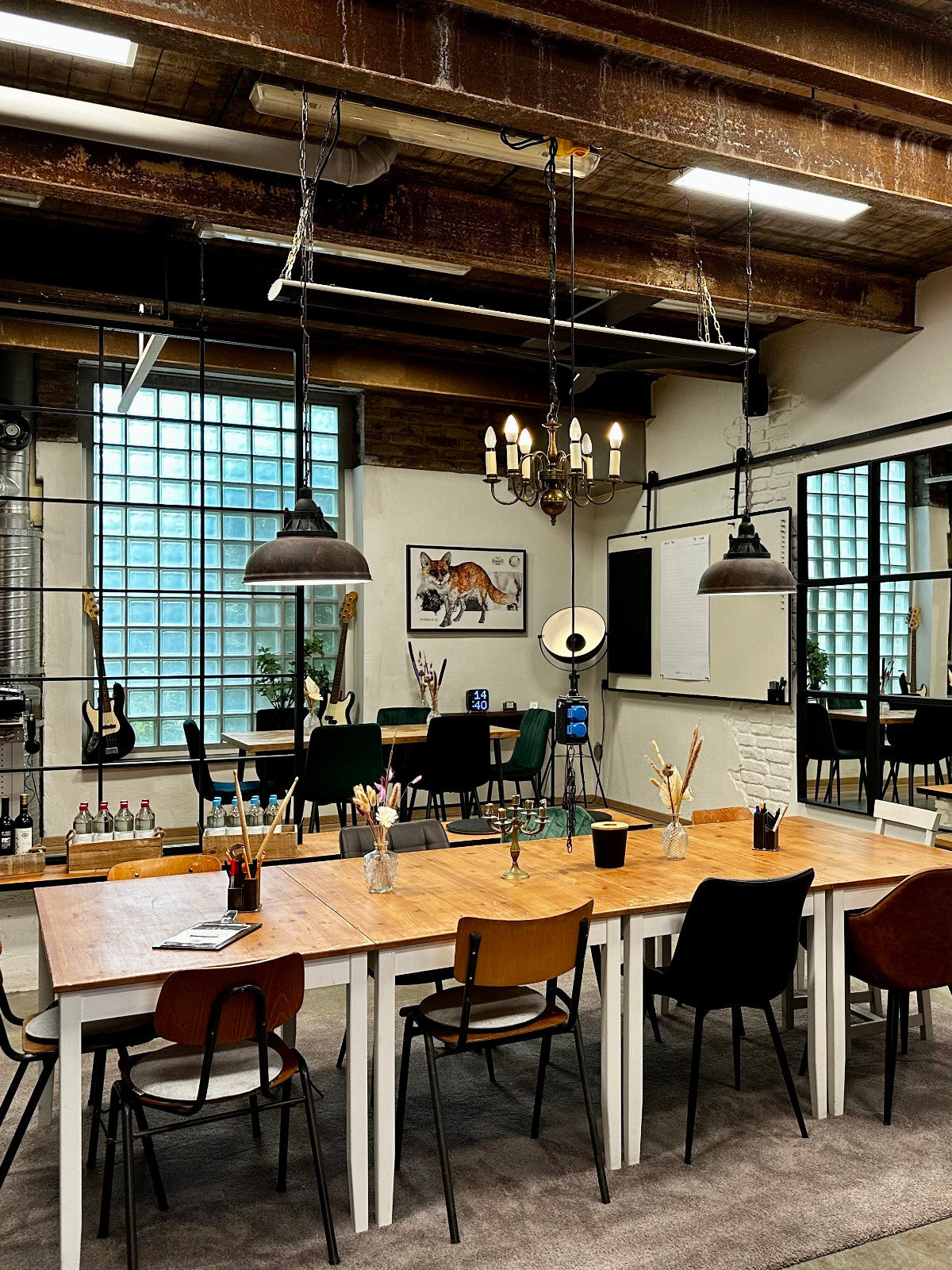 Seminarraum bei as/if spaces in Köln Nippes, ausgestattet mit Holztischen und Leinwand, ideal für kreative Meetings und Seminare.