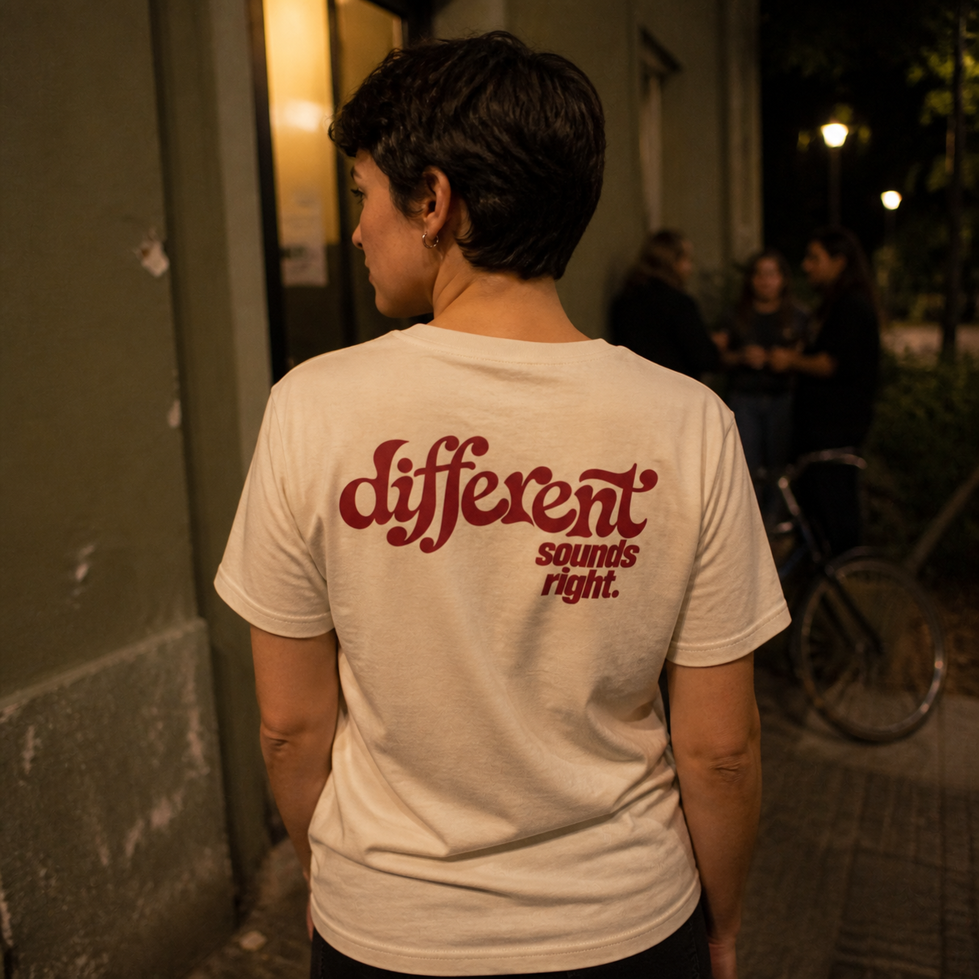 Different Sounds Right Bio-Tee in Natural Raw - Lifestyle-Rückenansicht vor einem Musikclub - as.if.threads
