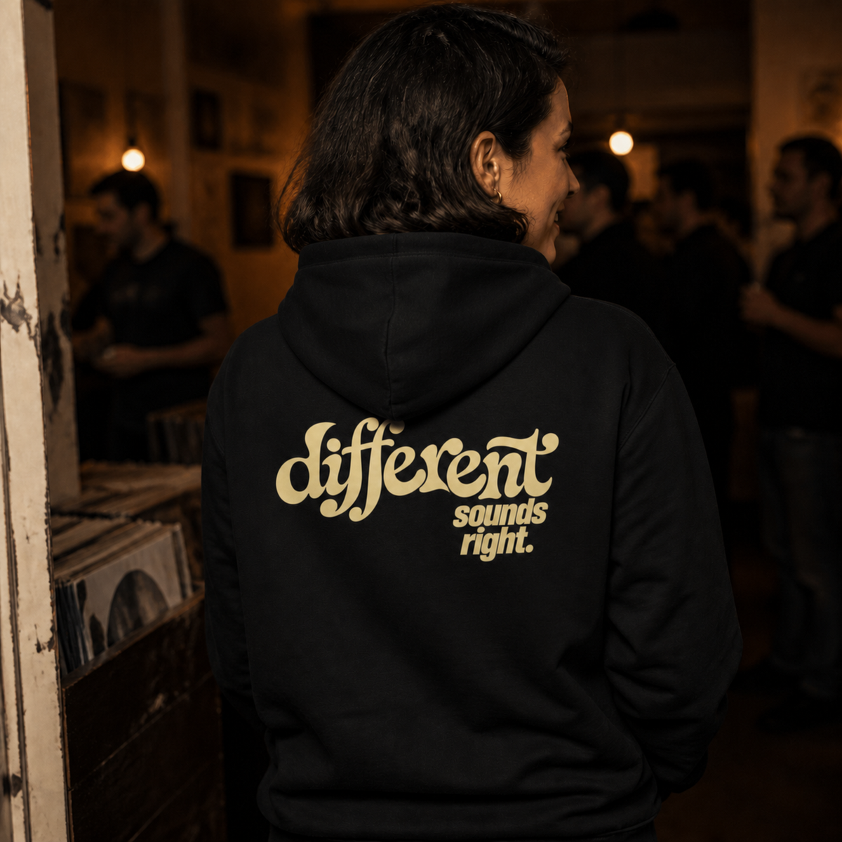 Different Sounds Right Bio-Hoodie in Black - Lifestyle-Rückenansicht im Plattenladen - as.if.threads